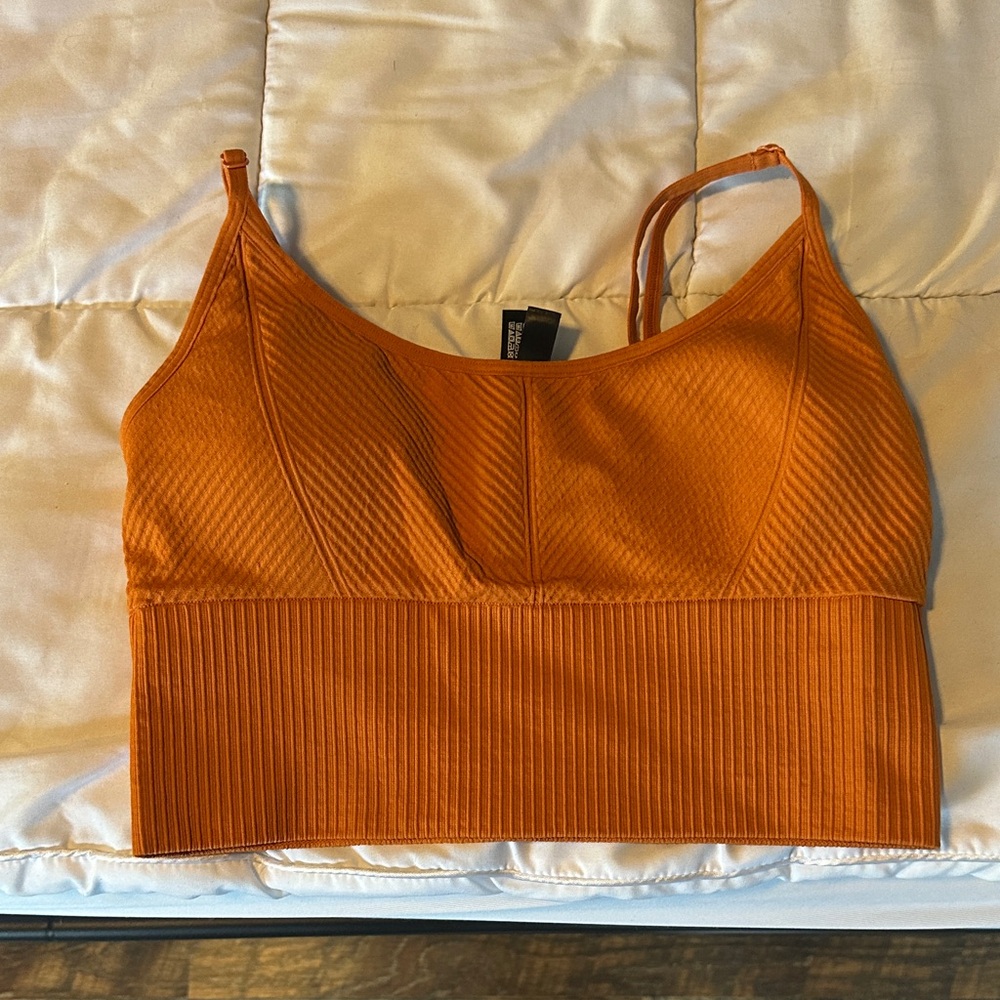 PINK Victoria Secret size Medium - seamless sports bra 
Orange in color